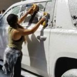 A dos manos Rosie enjabonada los autos para acabar más pronto