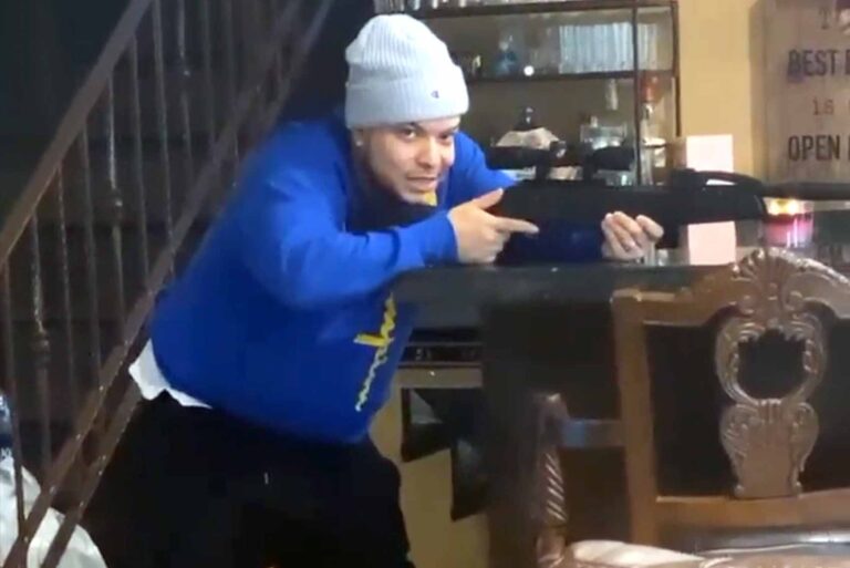 Lorenzo Méndez apunta un rifle en la sala de su casa (en la cuarentena)