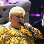 La verdadera causa por la que Paquita debe actuar sentada es por su ciática, que le provoca fuertes dolores en la espalda baja, que le impiden estar de pie